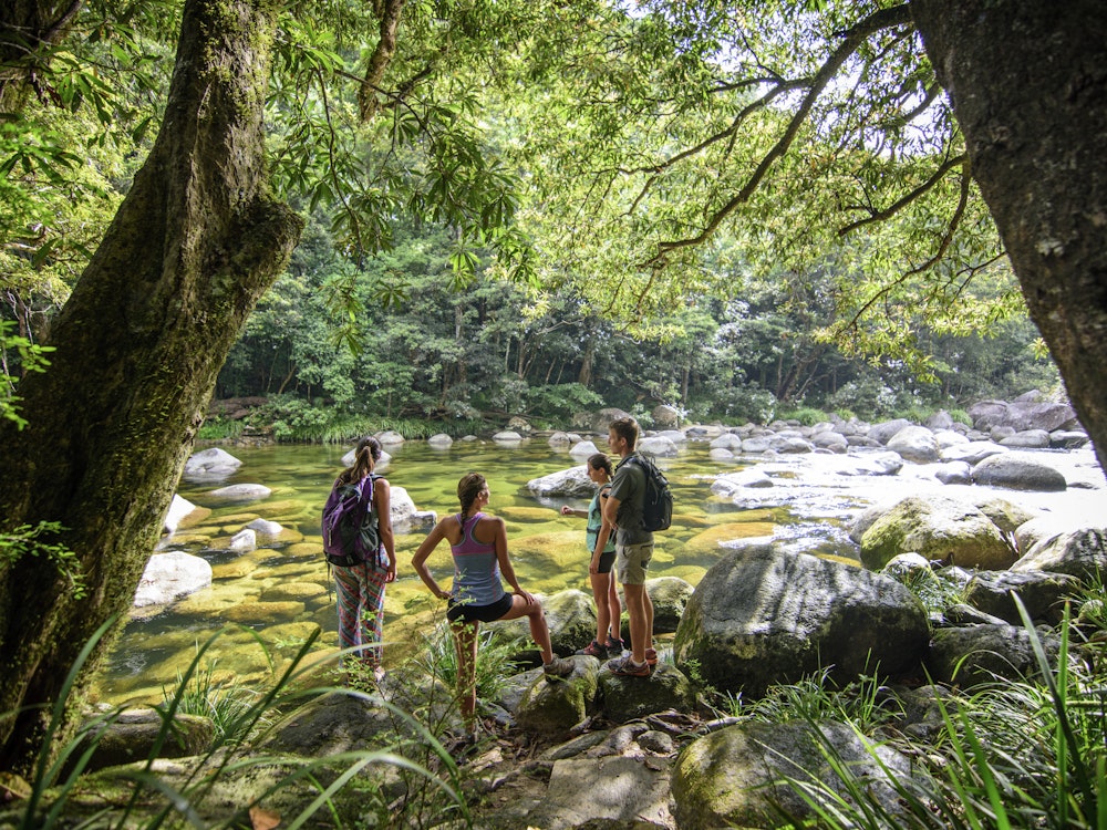 Reisegruppe steht zwischen Bäumen am Fluss in Queensland