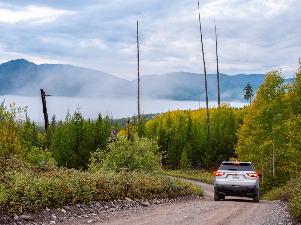 Een auto rijdt door de bossen van Glacier National Park