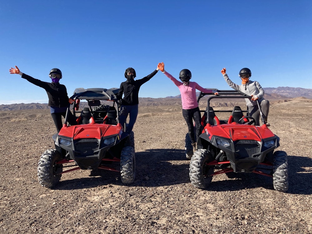 Vier Personen fahren mit zwei Buggys in der Wüste Moab