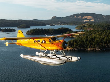 Watervliegtuig vliegt boven water en bossen bij Seattle