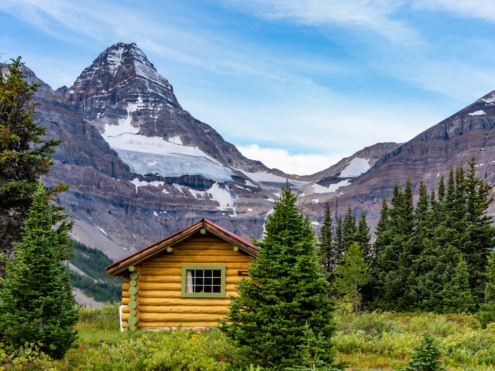 Holzhütte in Assiniboine Provincial Park mit Bergen im Hintergrund