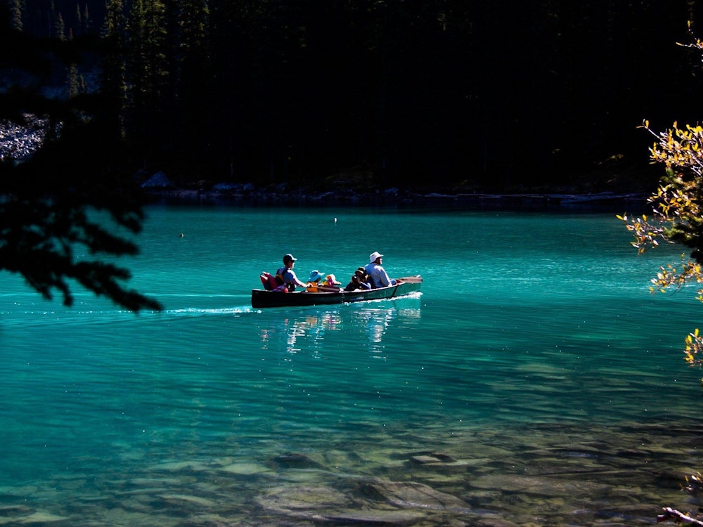 Een gezin zit in een kano op Moraine Lake in Canada