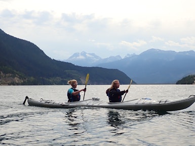 Twee vrouwen kajakken op een meer in Revelstoke Canada