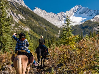 Twee mensen rijden paard door Banff National Park Canada