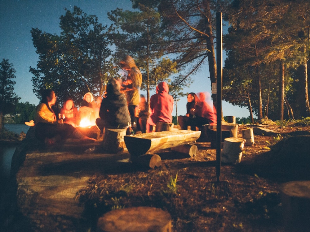 Freunde sitzten nachts am Lagerfeuer in Kanada