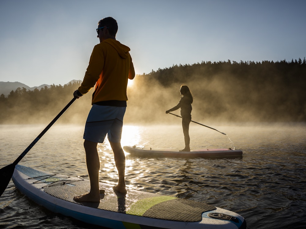 Een koppel doet aan stand up paddling op een meer in Canada