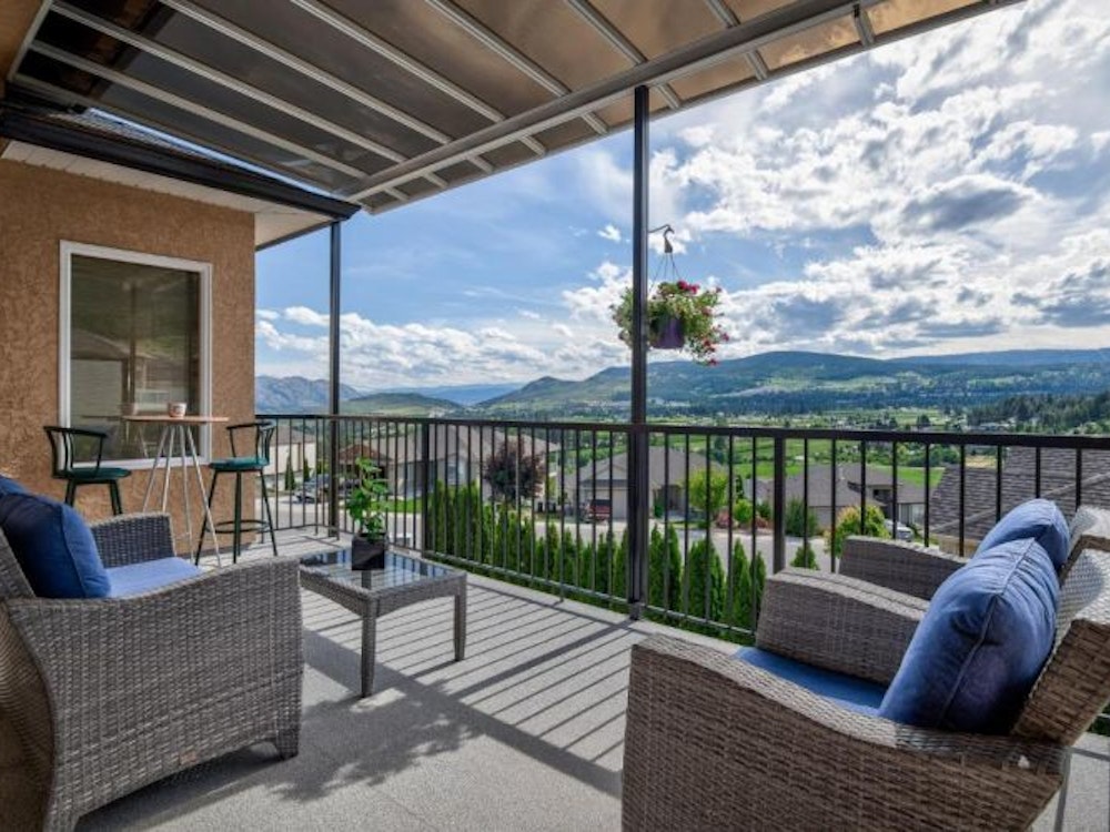Terrasse mit zwei Sesseln und Tisch, Blick auf die Berge