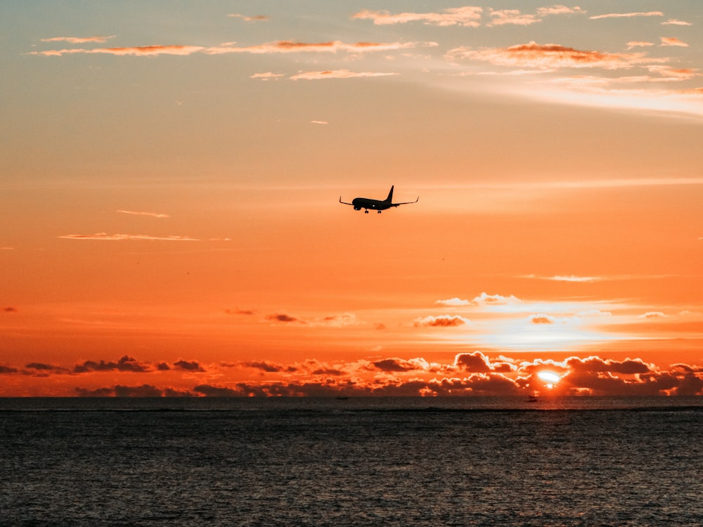 Vliegtuig landt tijdens zonsondergang
