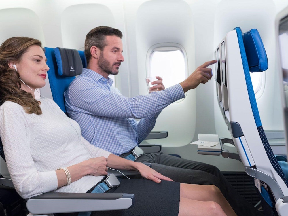 Een man en een vrouw zitten in een vliegtuig