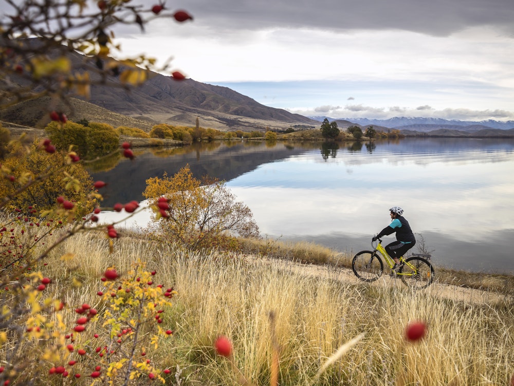 Een man fietst langs het Lake Wanaka