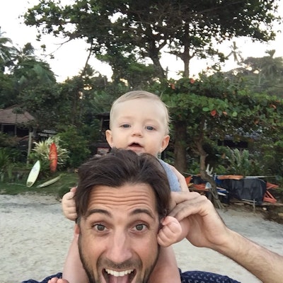 Reisexpert Michiel afgebeeld met baby op zijn rug