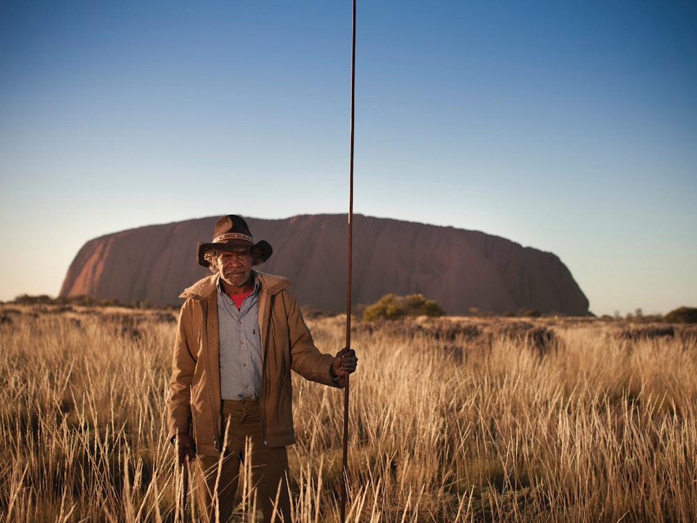 An Aboriginal guide standing in front of Uluru