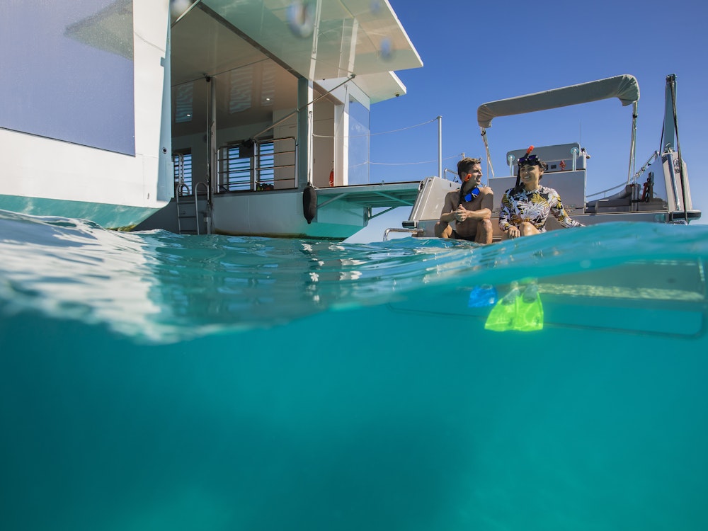 Man en vrouw gaan snorkelen in het Great Barrier Reef