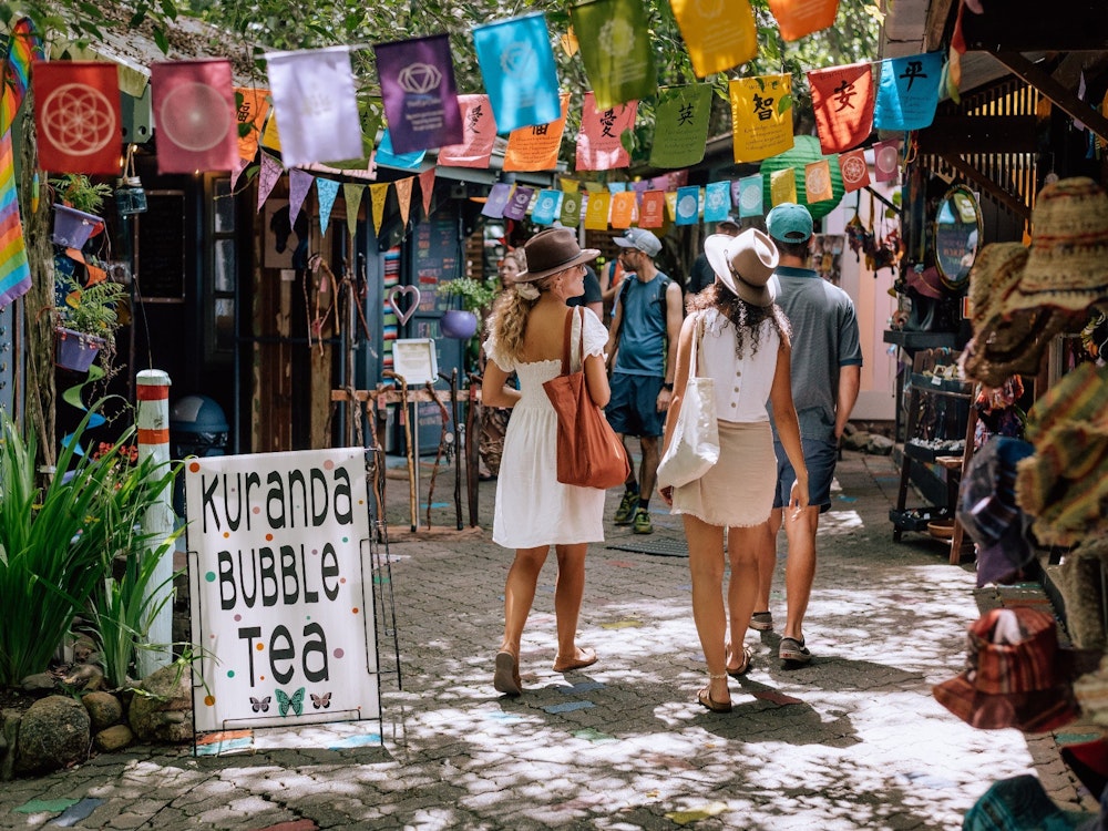 Twee vrouwen lopen over de pittoreske Kurana Original Rainforest Markets
