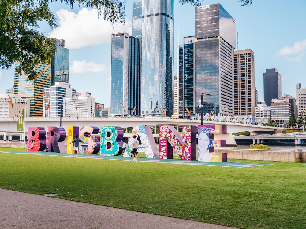 Bunter Brisbane Schriftzug mit Wolkenkratzern im Hintergrund