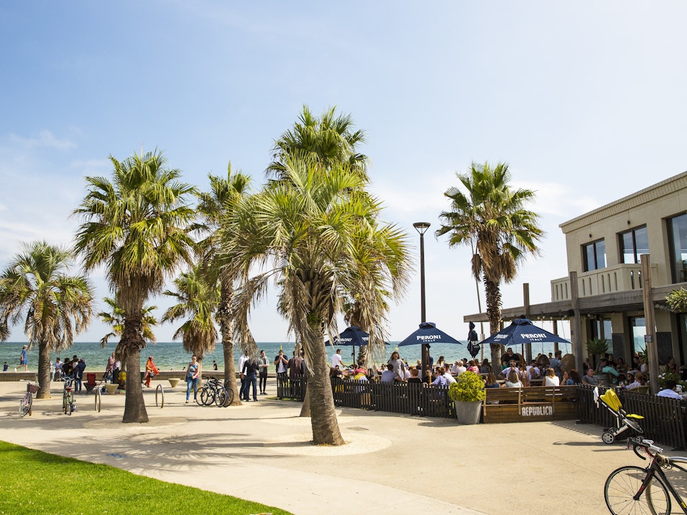 Wuivende palmbomen en een terras bij St Kilda Beach in Melbourne