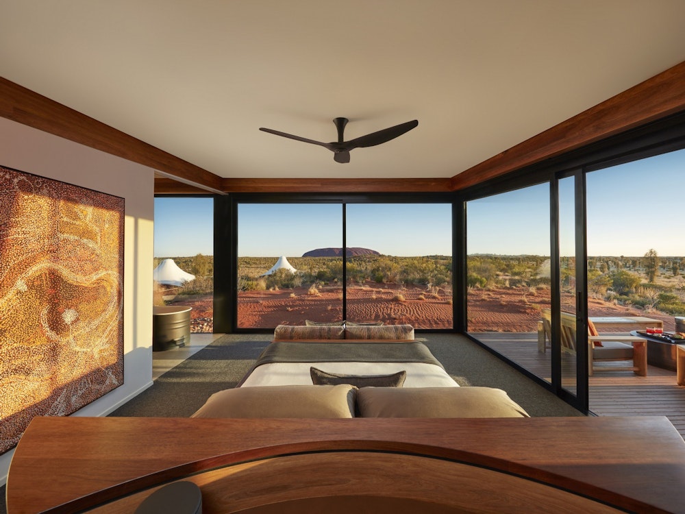 Schlafzimmer mit großen Glaswänden mit Blick auf den Uluru