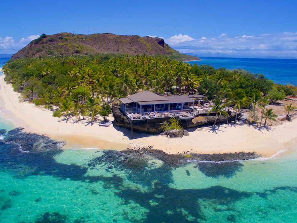 Een van de eilanden van Fiji van bovenaf gefotografeerd, met witte stranden en turquoise zee