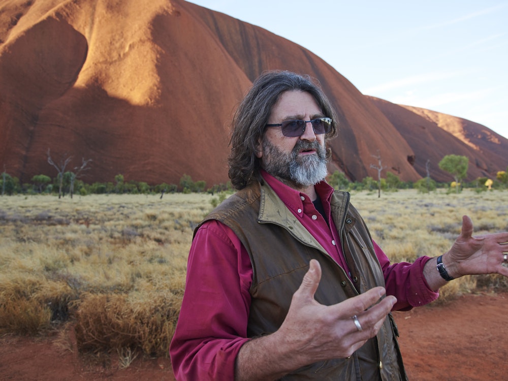 Ein Wayoutback-Guide steht erklärend vor dem Uluru im Northern Territory