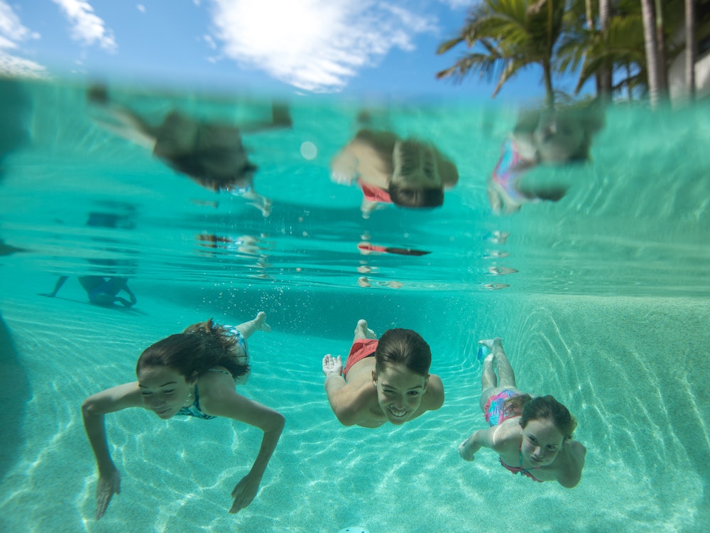 Kinderen die onderwater zwemmen in een zwembad in Australië