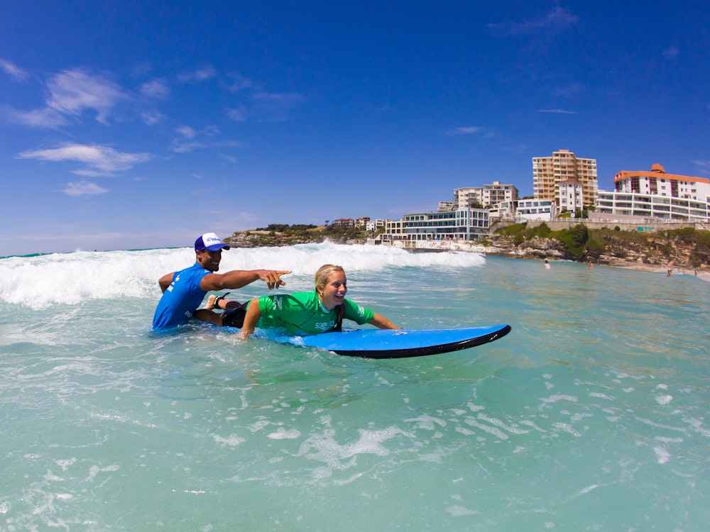 Een meisje op een surfplank onder begeleiding van een surfleraar in Bondi Australië