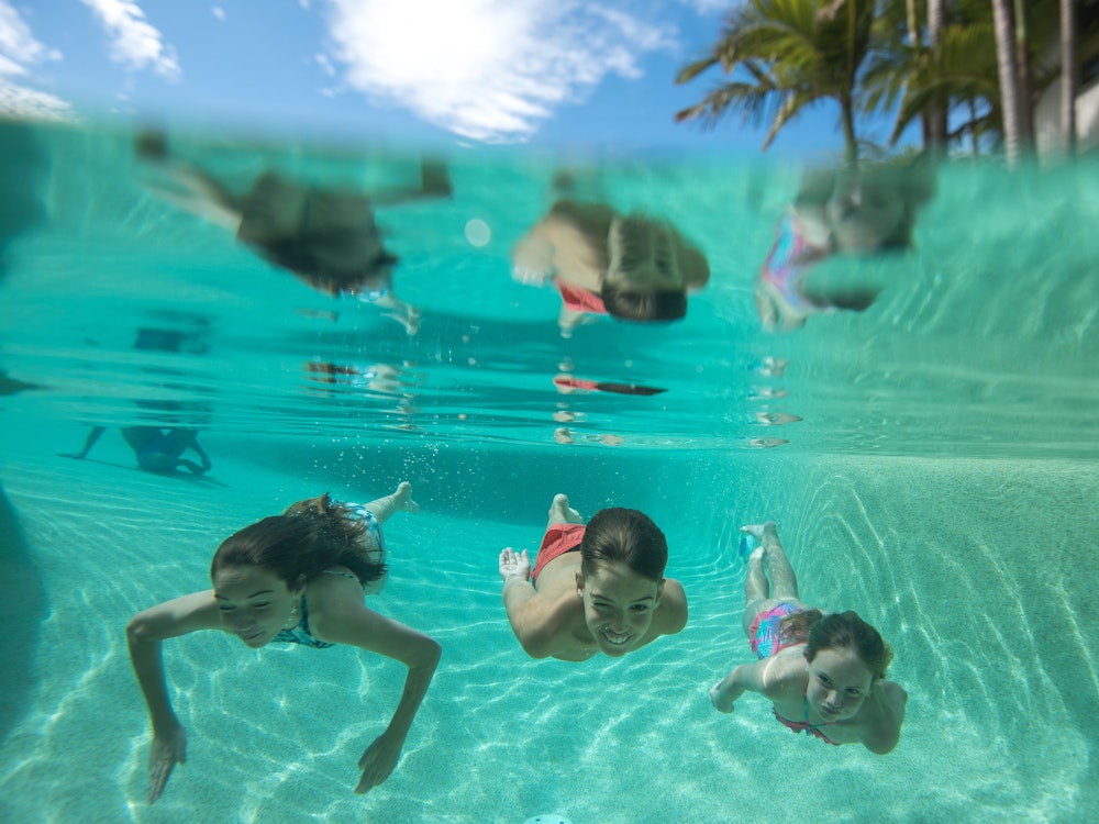 Three children swimming in a pool
