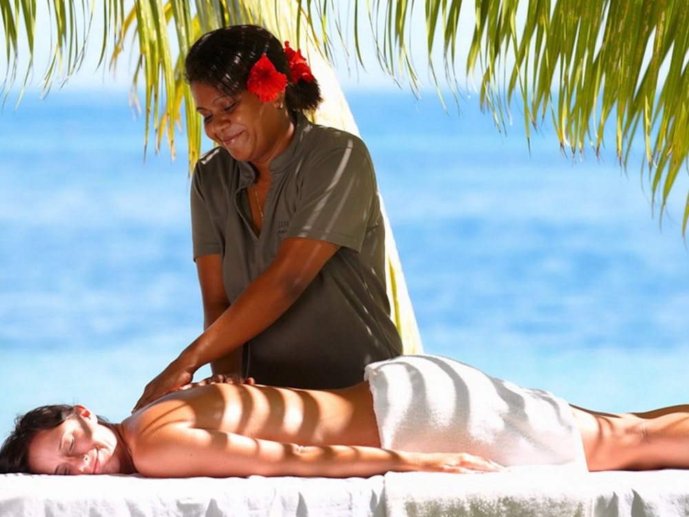 Een vrouw krijgt een massage op het strand van Fiji