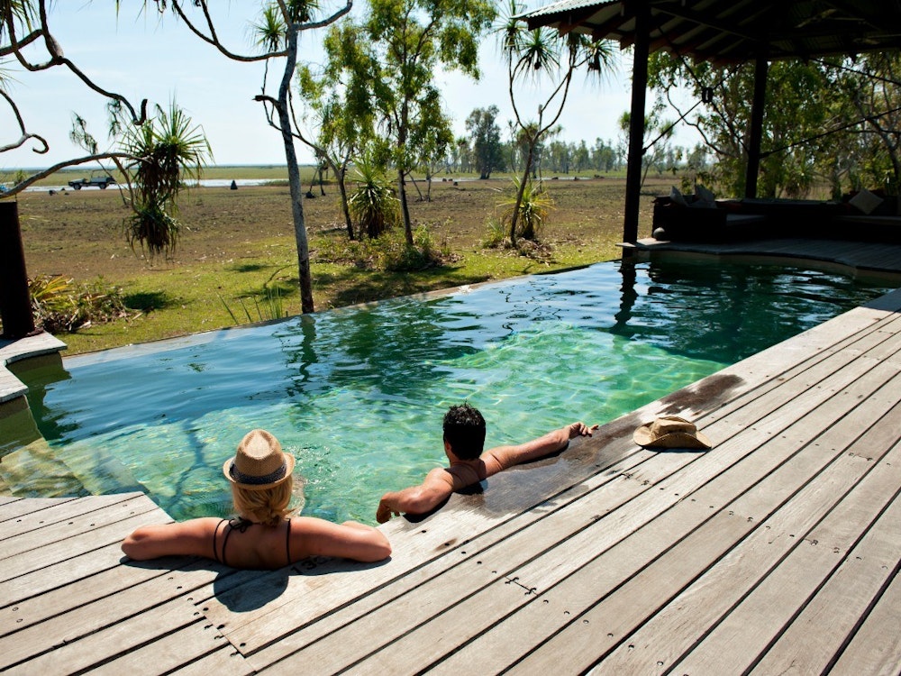 Een koppel geniet in een rustig zwembad met uitzicht over de Australische bush