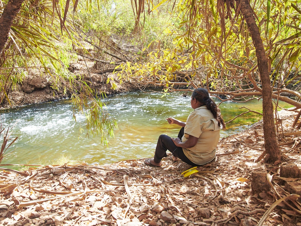 Aborigine Guide sitzt an Fluss im Litchfield Nationalpark