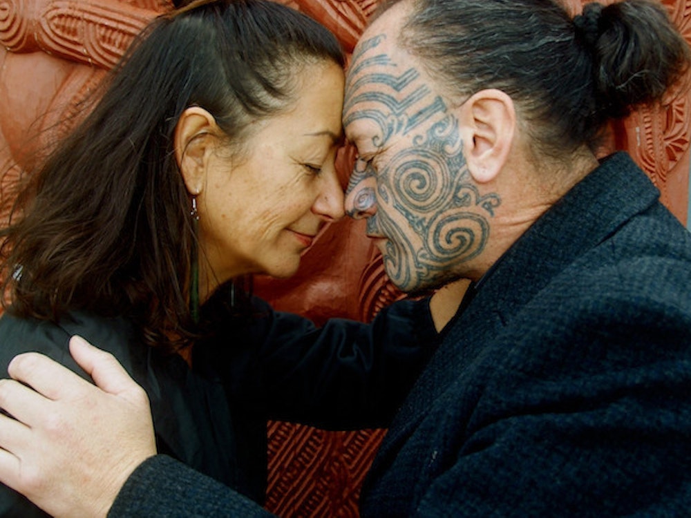 Wikitoria grüßt einen tätowierten Maori mit einem Hongi in Rotorua