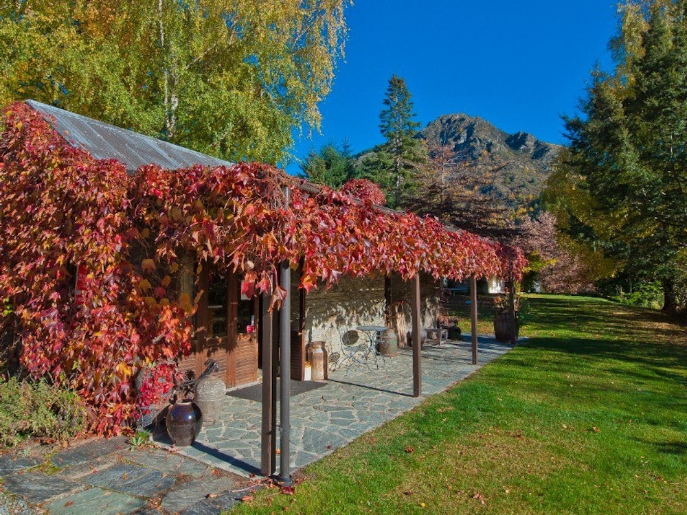 Rote Weinreben hängen an einem Cottage in Arrowtown Neuseeland