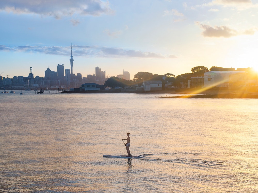 Een vrouw op een stand up paddle board in Auckland