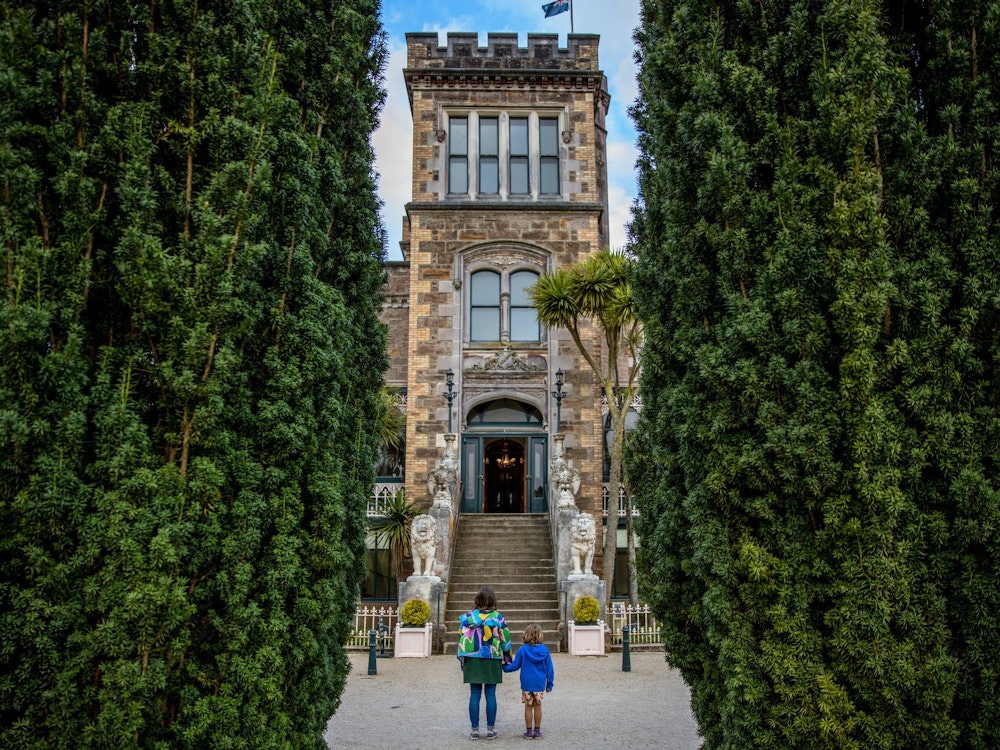 A girl and boy standing at the entrance of a castle