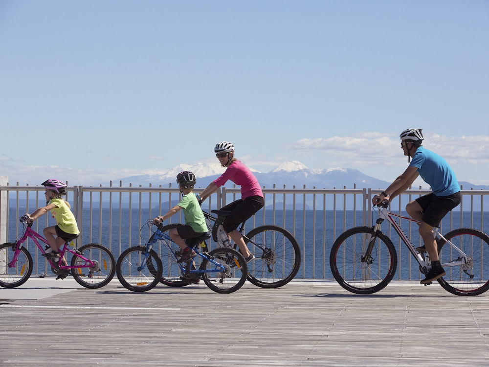 Een familie fietst over de Tongariro River Trail