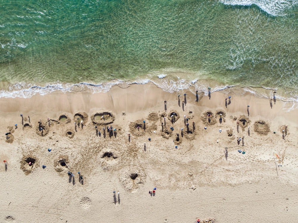 Gaten in het zand gegraven op Hot Water Beach in de Coromandel