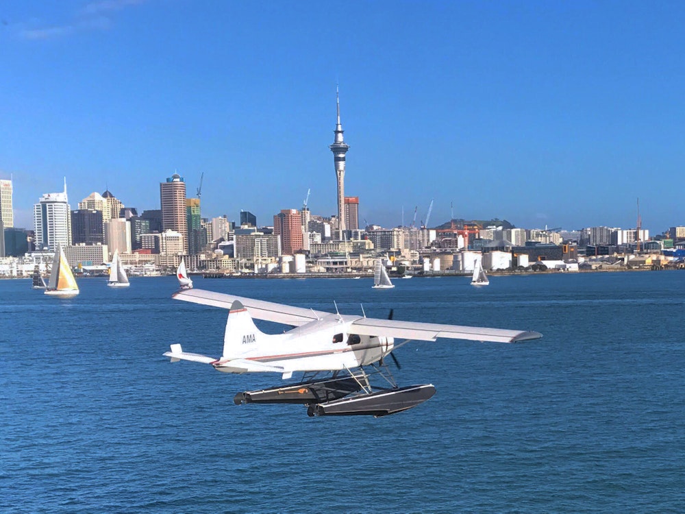 Zeevliegtuig voor de skyline van Auckland