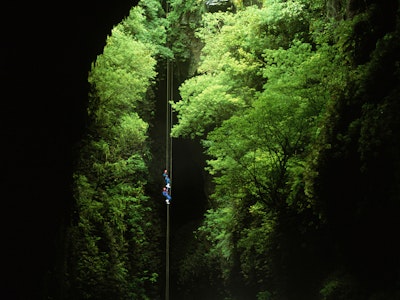 Twee mensen dalen af naar de Waitomo-grotten
