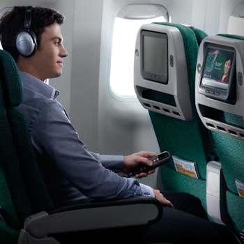 Mann schaut auf Bildschirm in Flugzeug nach Neuseeland