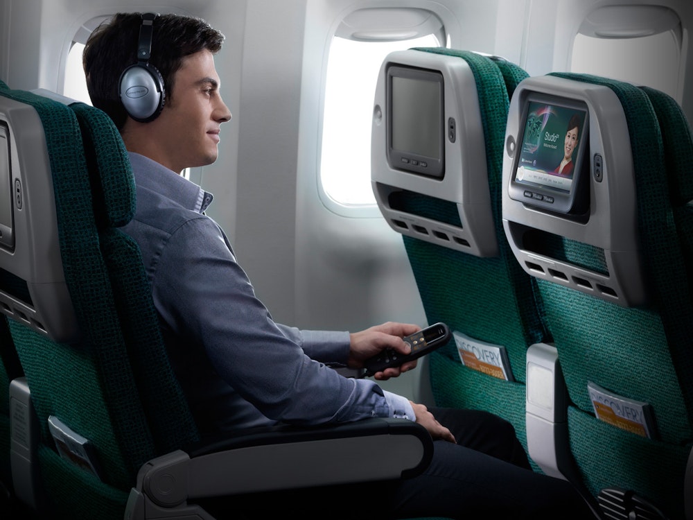 Mann schaut auf Bildschirm in Flugzeug nach Neuseeland
