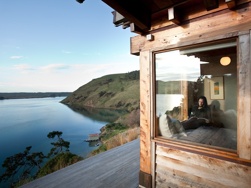 Mann entspannt in Hütte am Wasser in Neuseeland