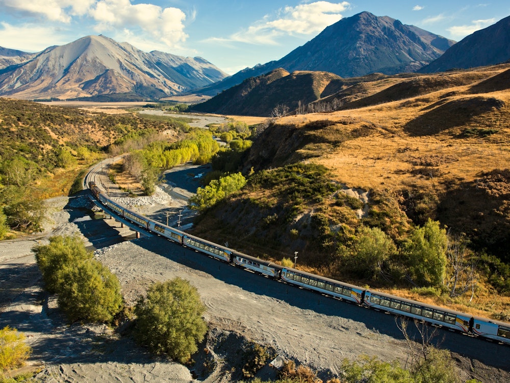 Een trein rijdt dwars door de bergen in Nieuw-Zeeland