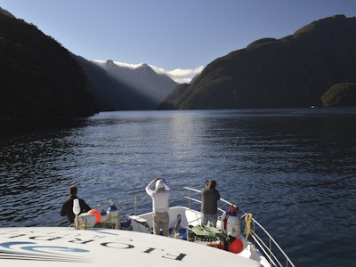 Mensen op een boot kijken uit over Doubtful Sound Nieuw-Zeeland