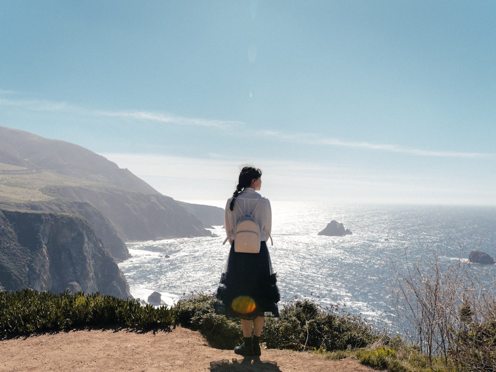 Een vrouw kijkt uit over de zee bij Big Sur in Californië VS